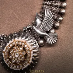 A detailed shot of the Mystic Wings choker, highlighting the craftsmanship of the silver bird and the polki medallion.