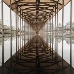 The perfect symmetry of a footbridge reflected in a puddle after the rain. This shot creates an infinite-seeming tunnel, playing with reflection and perspective.