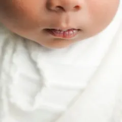A macro shot focusing on the tiny, perfect shape of a newborn's lips. This is part of my fine art approach to newborn photography, celebrating every small detail.