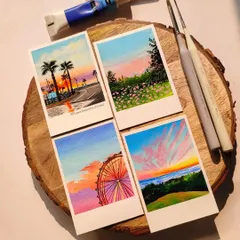 A closer look at some of my customized polaroid paintings. I use acrylics to create these vibrant sunset scenes, from palm tree-lined roads to colorful Ferris wheels. Each one is a little painted memory.