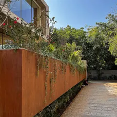 A detail of the planter box at the House of Terraces, finished in a corten steel look. The falling veils of green soften the modern architectural lines, demonstrating how I use planting design to add texture and life to a structure.