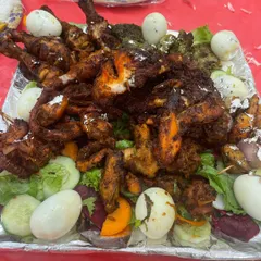 A grand platter of our non-veg starters. This includes tandoori chicken, hariyali kebabs, and fried chicken pieces, garnished with boiled eggs and fresh salad for a stunning presentation.