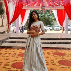 This is a light blue lehenga with a pleated skirt, paired with a crop top that has pink floral embroidery.