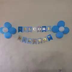 A simple and sweet "Welcome Baby Boy" decoration. This setup includes a blue and gold banner flanked by two blue and white balloon flowers, perfect for a low-key home celebration.