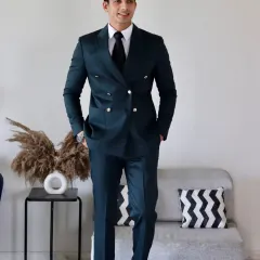 A full-length view of the deep teal double-breasted suit. The sharp tailoring and silver button details create a powerful silhouette that demands attention in any room.