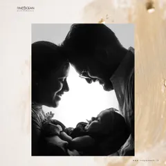 This is the art of connection. A beautiful black and white silhouette captures the pure love between new parents as they gaze down at their baby, their faces forming a circle of love around their new world.