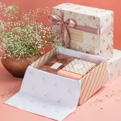 A gift should be beautiful inside and out. This image captures the elegance of our packaging, with delicate floral prints, premium paper, and a perfectly tied ribbon, promising a luxurious experience from the very first glance.