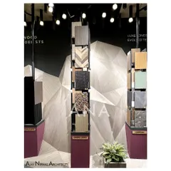 A detailed shot of the veneer samples on display at the Pllum Legno booth. The variety of textures and patterns, from wood grain to terrazzo, is highlighted by the focused lighting and clean presentation.
