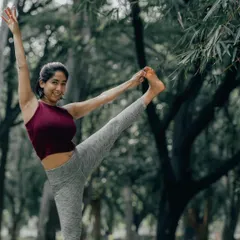 A joyful Utthita Hasta Padangusthasana, or Extended Hand-to-Big-Toe Pose, in the park. This posture is a fantastic way to challenge your balance while stretching your hamstrings.