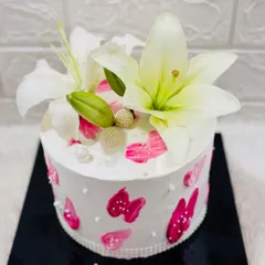 A simple and stunning cake named "Lily," adorned with fresh white lilies and abstract pink brushstrokes for an artistic touch.