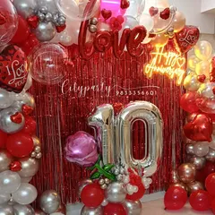 Another view of the 10th anniversary setup, showing the full balloon arch and the large silver '10' number balloons.