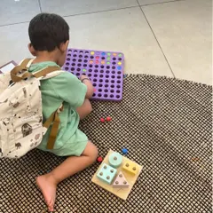 A quiet moment of focused play during our summer camp. This child is exploring shapes and patterns, demonstrating how our programs provide a balance of energetic group activities and calm, individual exploration.