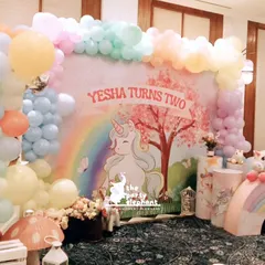 A different angle of the main unicorn backdrop, highlighting the layered balloon decor and whimsical props like the mushroom stool and lanterns.