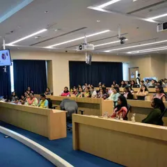 An audience of professionals at a corporate workshop, fully engaged in the session. My goal is to make learning interactive and relevant to their work.