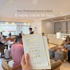 Your Pinterest board called. It wants you to be here. A customer holds up a book with a positive message, reflecting the good vibes of our space.