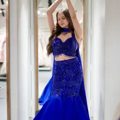 Blue dreams stitched in shimmer. This royal blue fish-cut lehenga features a modern bustier-style blouse and a dramatic mermaid skirt, perfect for making a bold statement.