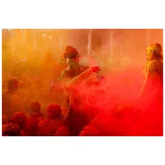 A cloud of red gulal is thrown into the air, enveloping the crowd at Nandgaon. My focus is on capturing the texture and movement of color that defines the Holi experience.