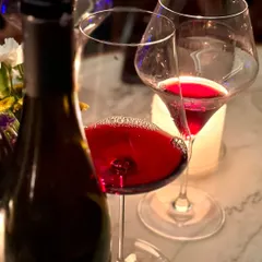 A close-up of a glass of rich red wine, poured during one of our tasting events. This image captures the sensory experience of our wine program, focusing on the color, aroma, and quality of the curated selections we offer.