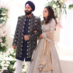 Here is another look at the stunning couple from their sangeet. This view shows how his dark, detailed jacket provides a beautiful contrast to her light, sparkling lehenga, creating a balanced and visually captivating coordinated look as they make their entrance.