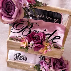 A stunning floral arrangement on a wooden crate hamper for the bride. This gift includes a personalized 'Bride' robe, 'Hers' towel, and a sleep mask.