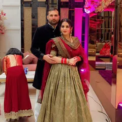 A classic look for a new bride. This custom-designed lehenga combines a traditional olive-green skirt with a rich red embroidered dupatta, creating a beautiful contrast that’s perfect for post-wedding festivities.