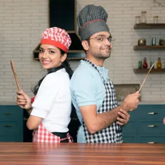 Another shot from our popular chef-themed pre-wedding shoot. The couple stands back-to-back with wooden spoons, ready for a cook-off, showcasing a creative and lighthearted approach to engagement photos.