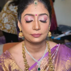 A close-up of the makeup for this beautiful mother. The focus is on creating a smooth, luminous base and using soft colors that complement her purple silk saree.