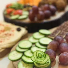 It's all in the details. Here, a cucumber is carved into a delicate rose, adding an artistic touch to a platter of fresh vegetables and dips. This is how I make every food display special.
