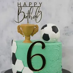 Score a goal with this football-themed birthday cake. Perfect for young sports fans, this cake is decorated with edible soccer balls, a trophy, and can be customized with any age and name.
