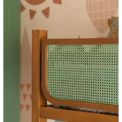 A close-up of the mint green rattan panel on the bunk bed, a detail that adds a pop of color and texture.