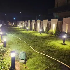The final result of the lawn renovation. A perfectly green, manicured lawn complemented by modern lighting along the boundary wall, creating a high-end, resort-like feel for this large property.