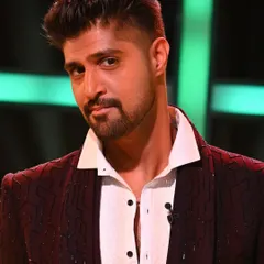 A close-up of Tanuj Virmani wearing another one of our creations for MTV Splitsvilla. This deep maroon jacket features subtle, sparkling embellishments, showcasing our range of stylish tuxedos and cocktail jackets.