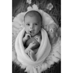 An awake baby's bright-eyed expression is beautifully captured in this black and white portrait. The lack of color draws all attention to his engaging gaze and happy face.