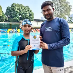 We celebrate every milestone with our swimmers. Here, one of our dedicated coaches from the Sportiqo Swim School congratulates a young student for his hard work and promotion to the next level.