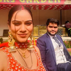 A selfie of a client and her partner at an outdoor wedding function. She is wearing a beautiful red choker and matching oversized earrings from my collection.
