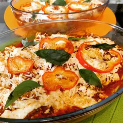 Our homemade vegetarian lasagna, baked to perfection with layers of pasta, rich tomato sauce, vegetables, and melted cheese, garnished with fresh basil.