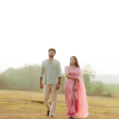 Walking through a misty field at dawn. The high-key lighting and foggy backdrop give this pre-wedding photo a dreamy, ethereal quality.