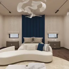 A contemporary bedroom where a deep blue upholstered headboard provides a rich pop of color. The sculptural ceiling light adds an artistic touch, while the curved chaise lounge offers a comfortable spot to relax. It's a balance of bold statements and soft comforts.