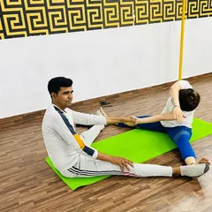 Here, I am providing an assist in a seated wide-legged stretch. This kind of hands-on help ensures you get the correct alignment for a deeper, more effective stretch.