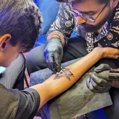 The tattooing process in action. You can see me carefully wiping the area to ensure clean lines and proper ink saturation, following strict hygiene protocols throughout.