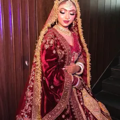 A look at a royal maroon velvet bridal lehenga. The intricate gold embroidery and the heavy velvet fabric give it a very regal feel, ideal for creating timeless and classic wedding photos.