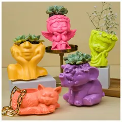 My collection of handcrafted Jesmonite planters is all about adding a pop of personality to your space. This image shows the variety of quirky, vibrant figurine shapes I offer, from playful cats to serene angels, each ready to hold a small plant or your favorite trinkets.