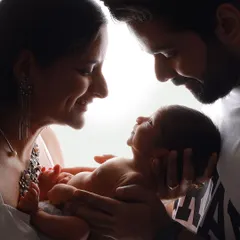 An artistic portrait capturing the beautiful silhouette of new parents admiring their baby. This style of photography creates a powerful and timeless image of your new family.