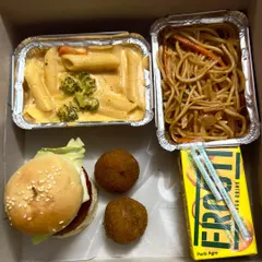 Here's another example of a customised kids' snack box. It includes a mini veg burger, cheese balls, creamy pasta, and a Frooti, making it a fun and filling treat for any children's event.