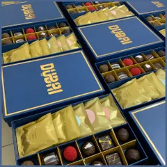 Our custom corporate chocolate boxes are designed to impress. These elegant blue boxes with gold foil branding are filled with an assortment of gourmet chocolates and wafers.