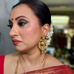 A beautiful side profile showing how the makeup sits flawlessly on mature skin. The focus is on enhancing the bone structure with soft contouring and highlighting, avoiding any heavy or cakey texture.