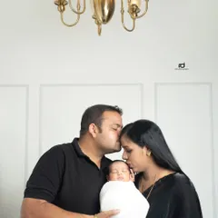 Kisses from mom and dad. This is such a precious moment, with both parents showering their newborn with love. The simple white background keeps the focus on the family's bond.