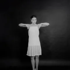 A black and white studio shot capturing a model in a dance-like pose, demonstrating movement and grace.