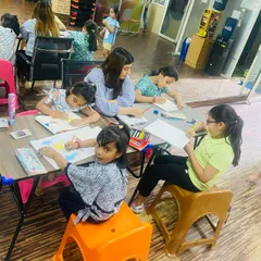 A snapshot of our group art workshop. Kids are sitting together, focused on their drawings and paintings. It's a great social activity that encourages creativity.