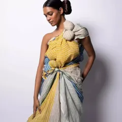 A studio shot of the Anavila Misra look, showing the elegant simplicity of the makeup and hair. The focus is on a flawless complexion and a neat, sculptural hairstyle that enhances the model's natural beauty.